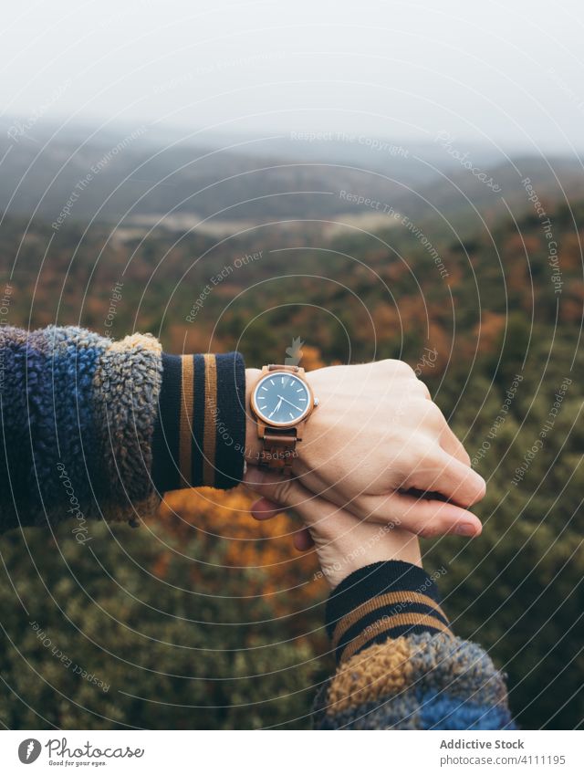 Traveler checking time on wristwatch travel hand modern style trendy nature forest hill autumn tourism adventure journey vacation explore hike landscape tree