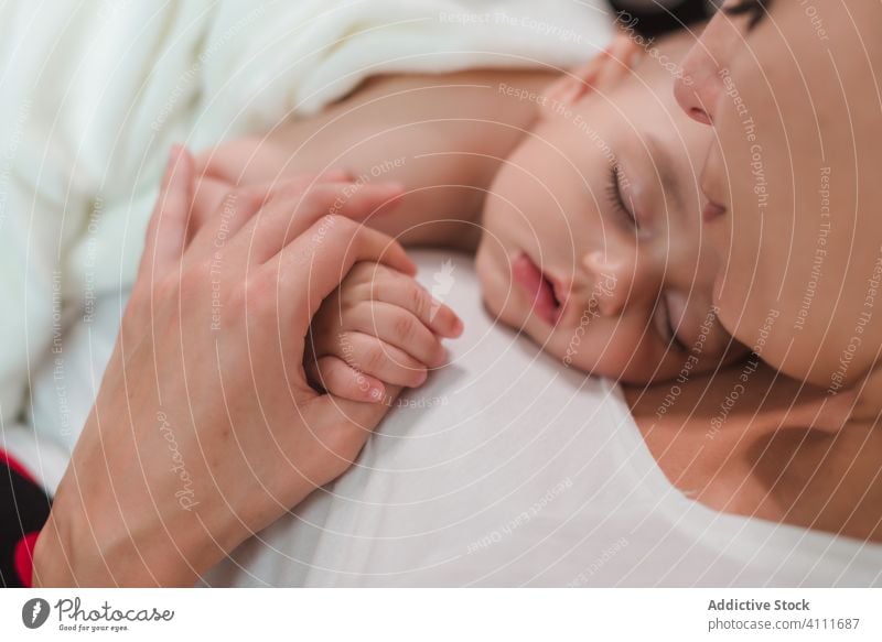 Peaceful baby on mother chest sleep together child adorable little cute innocent kid care relax rest love affection small comfort tender happy lying parent home
