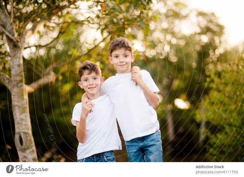 Happy twin boys hugging and looking at camera in park brother together embrace kid happy smile love child childhood nature alike summer cheerful bonding little