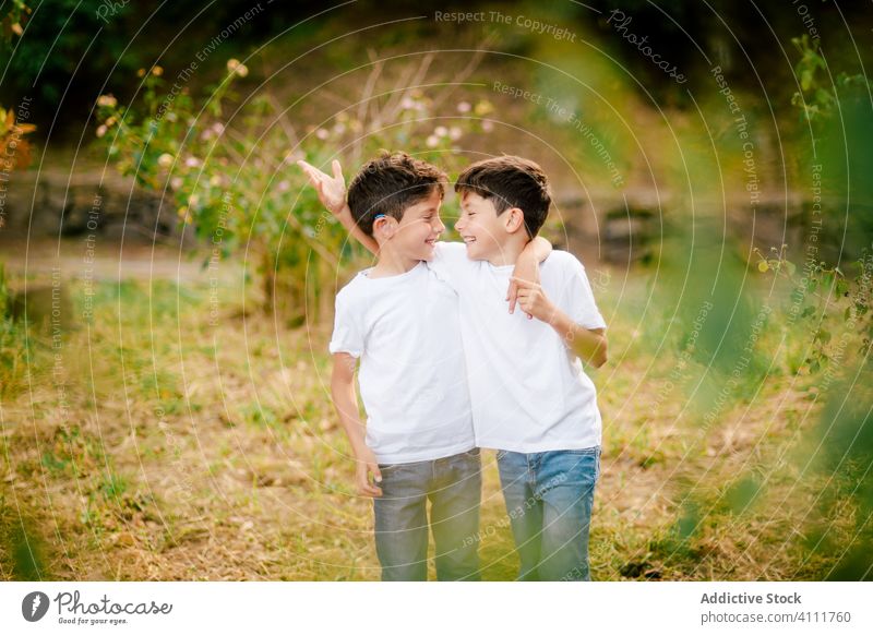 Happy twin boys hugging and looking at each other in park brother together embrace kid happy smile love child childhood nature alike summer cheerful bonding