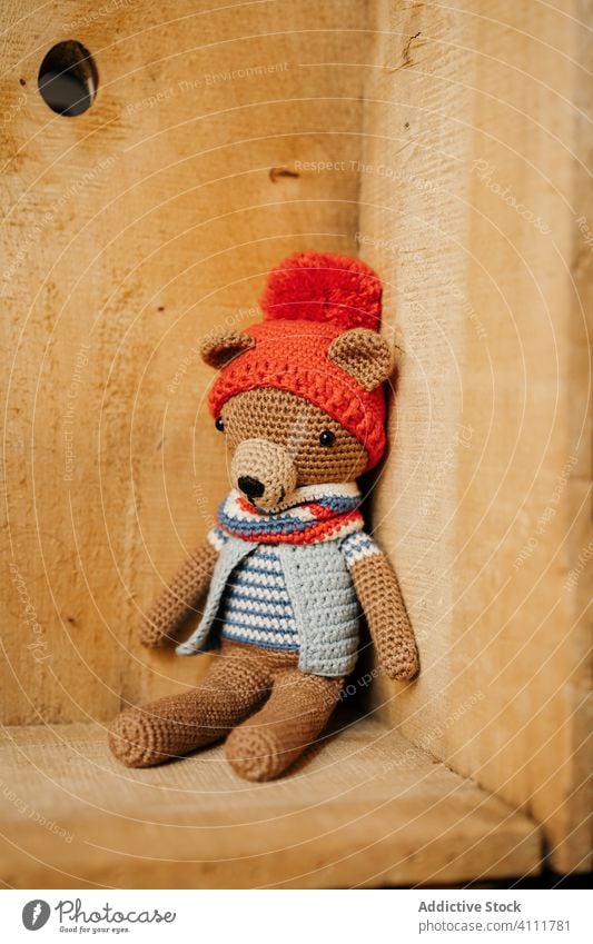 Knitted bear in wooden corner toy knitted cute cloth handmade soft workshop box wall design colorful yarn lovely adorable style trendy cozy ornament material