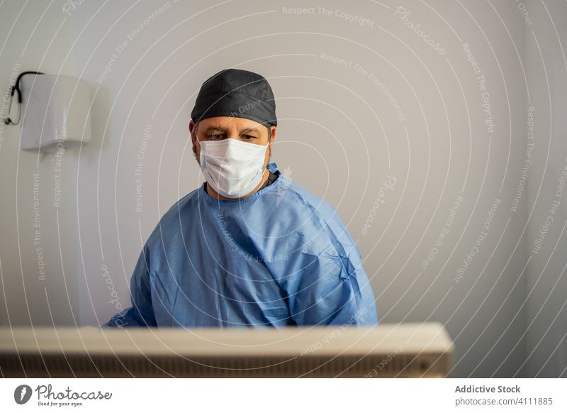 Doctor checking information on screen while performing diagnostic patient disease in contemporary clinic uniform hospital doctor medicine practitioner equipment