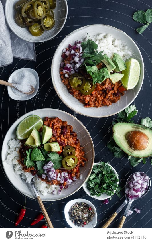 Served chili with rice and vegetables on table spicy avocado bowl tradition food mexican hot meat delicious tasty meal dish cuisine gourmet nutrition fresh
