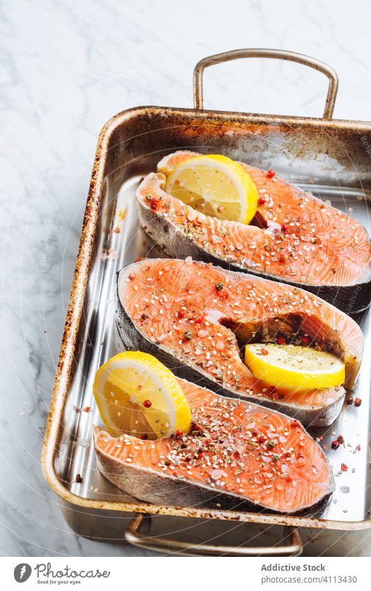 Fish steaks with lemon on baking tray fish salmon fresh raw seasoning prepare ingredient seafood healthy slice tasty natural meal citrus dish cuisine nutrition