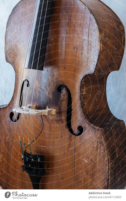 Brown wooden violin against wall music musician instrument grey classic string hobby equipment modern detail skill harmony tune culture entertain style home
