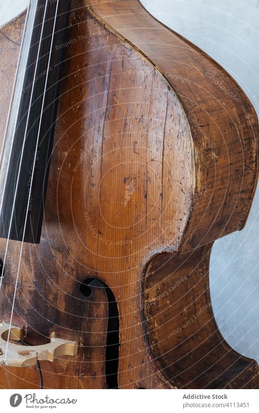 Brown wooden violin against wall music musician instrument grey classic string hobby equipment modern detail skill harmony tune culture entertain style home