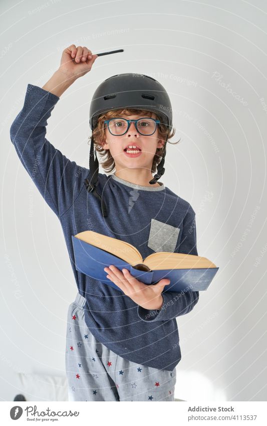 blond kid in pajamas with a helmet a flashlight and a book playing research comfort dream wow imagination comfortable kids joyful innocent emotional lifestyles