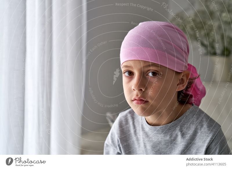 Adorable sick little boy in bandana in room cancer fight child small patient courageous disease male against awareness recovery strength kid willpower hope