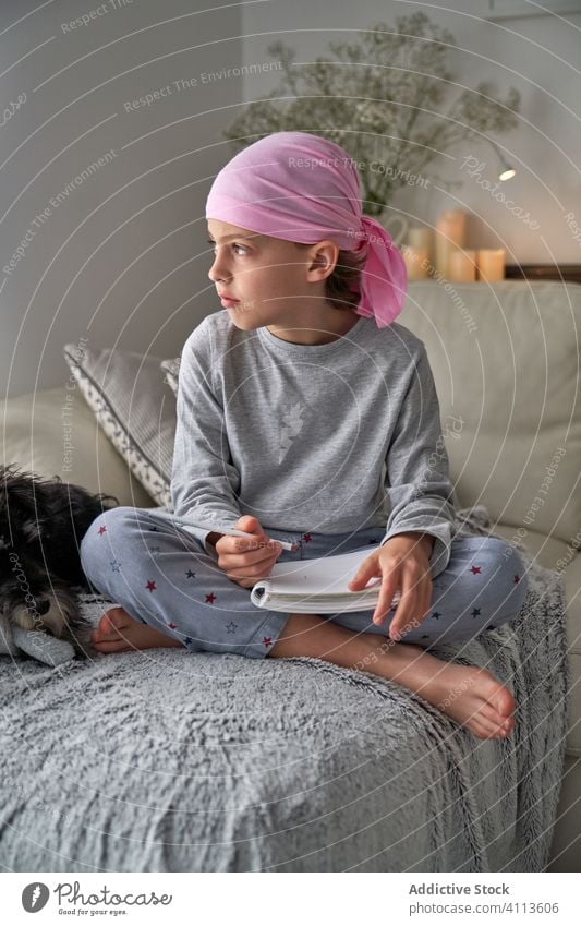 Focused little boy writing notes on bed write cancer diagnosis child home therapy male childhood faithful relax optimism awareness room pajama remission sick