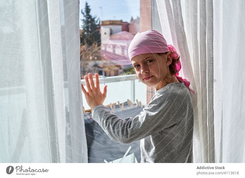 Sick child looking at camera at window sick kid cancer room fight small patient courageous male disease against awareness recovery strength willpower hope