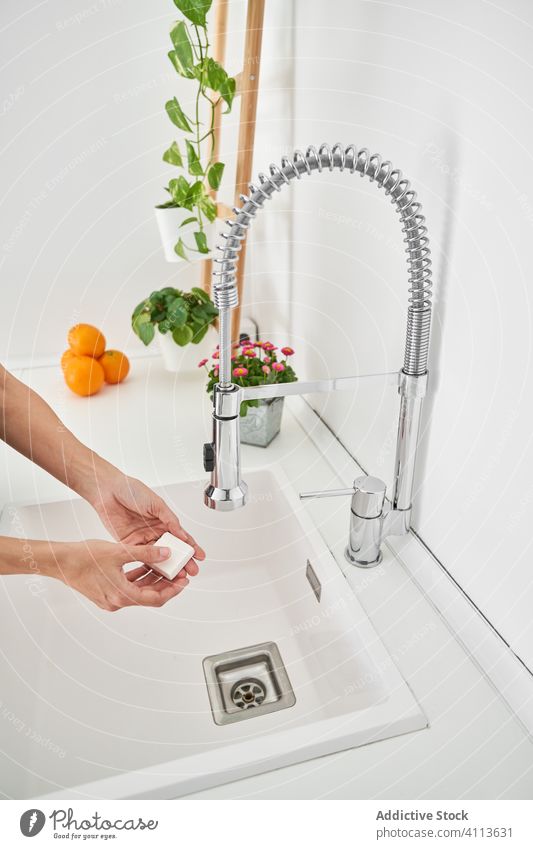 Woman washing her hands on the kitchen sink to avoid possible infection clean lifestyle hygiene home personal indoors faucet water cleaning house midsection