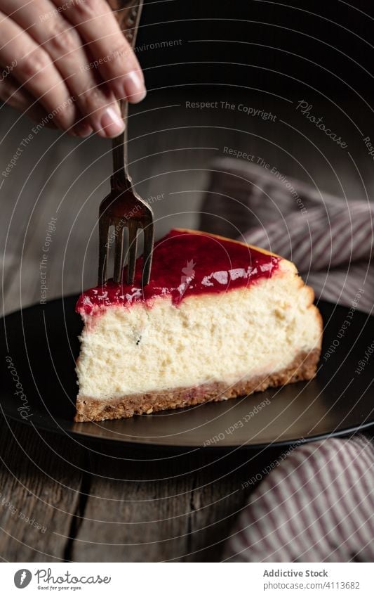 Woman eating delicious cheesecake with jam dessert sweet food piece fork hand tasty plate meal pastry homemade confectionery cuisine serve baked yummy slice
