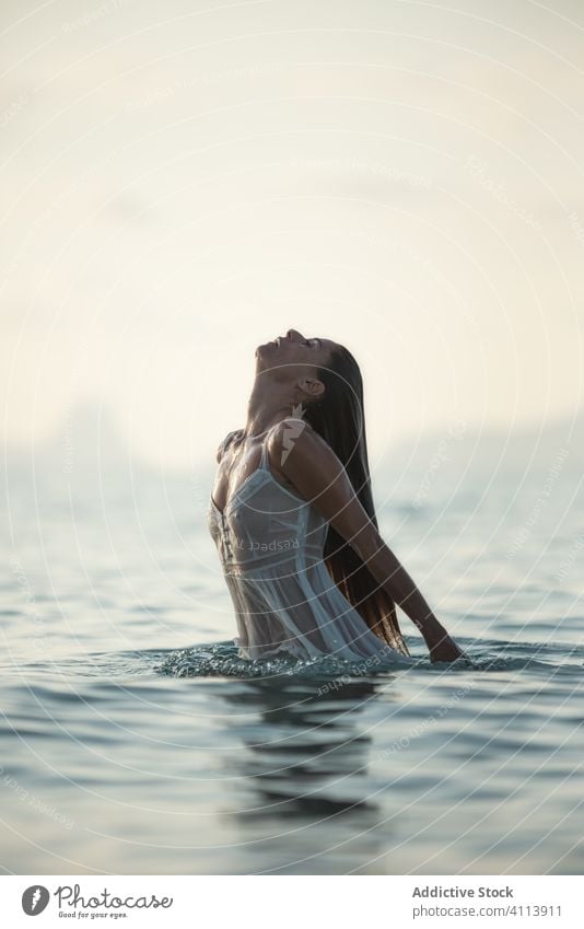 Woman in wet dress emerging from water woman sea emerge nature evening vacation sensual ocean female relax summer harmony calm slim weekend lady seductive