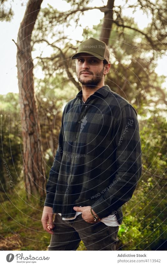 Man in checkered shirt and baseball cap in forest handsome male portrait casual man attractive hat adult person style thoughtful caucasian confident modern one