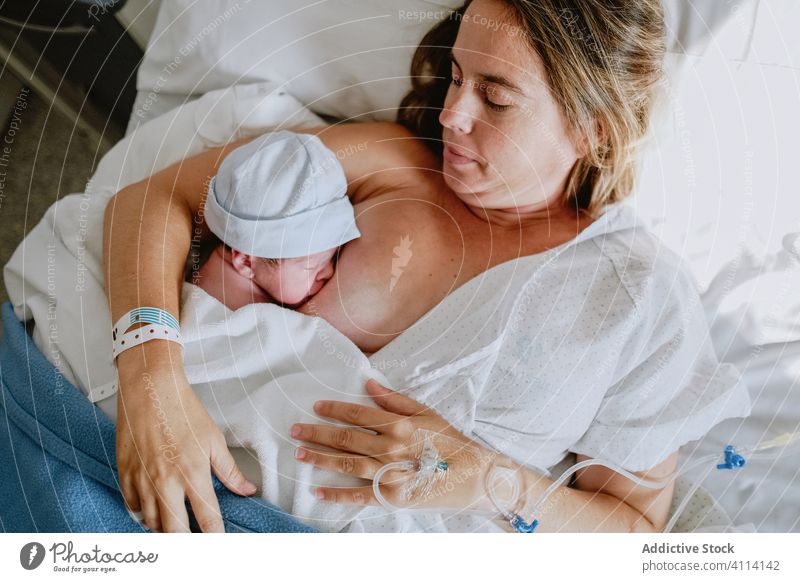 Mother breastfeeding her newborn son in hospital mother baby care neonatal bed woman child health care motherhood love cute kid tender maternal little childhood