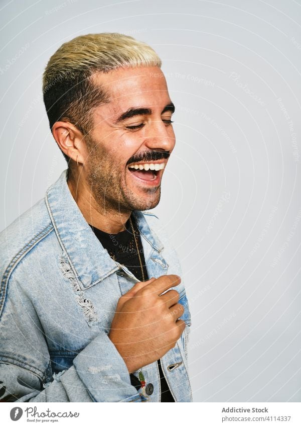 Cheerful man in stylish denim jacket style trendy laugh cheerful fun fashion outfit happy young unshaven guy handsome male modern hipster cool positive