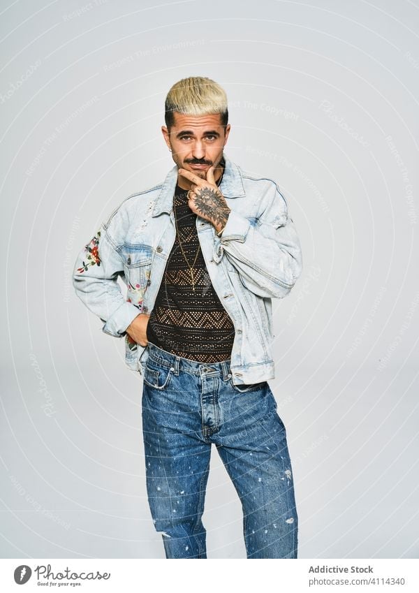 Stylish grimacing man in denim outfit trendy independent cool expressive grimace style modern hipster young ethnic male jacket mustache confident casual cloth