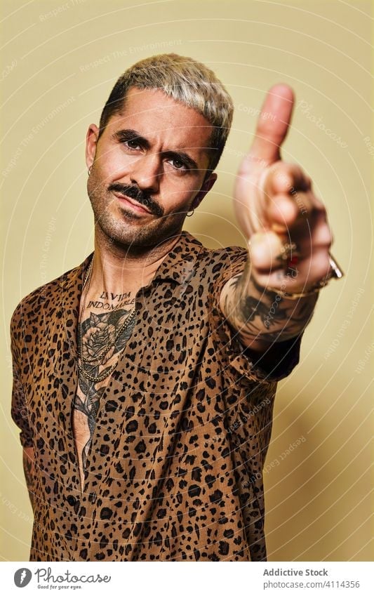 Confident stylish man in leopard shirt trendy style confident shoot gesture fashion finger gun model beard male ethnic cloth modern outfit handsome contemporary