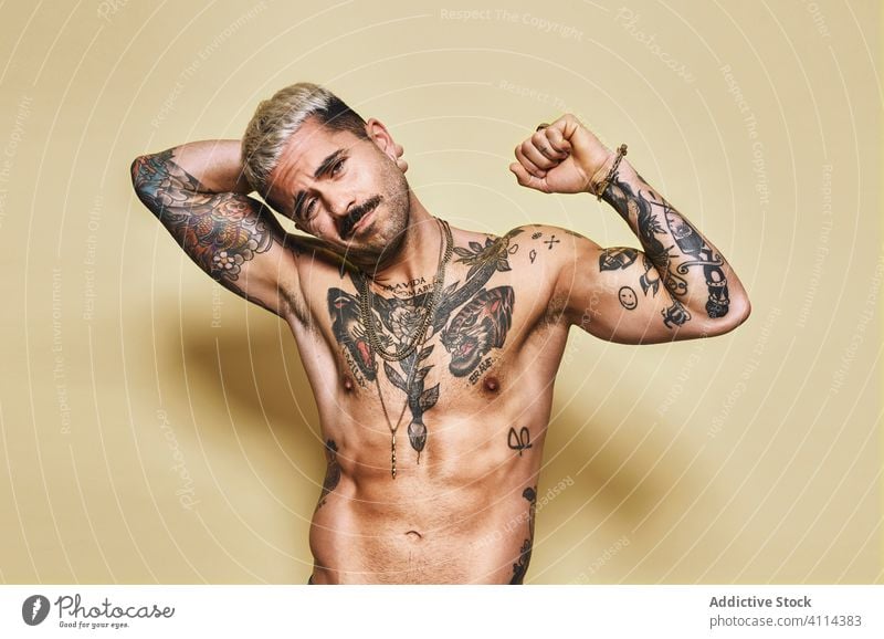 Shirtless cool tattooed muscular man in studio sexy macho naked torso handsome shirtless beard confident body athlete strong young model male seductive