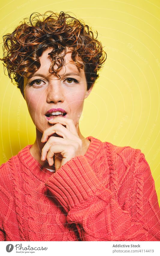 Excited woman in warm sweater in studio amazed happy surprise excited style trendy knitted curly hair joy casual glad expressive vibrant vivid color colorful