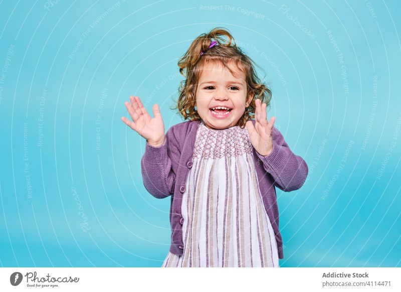 Cheerful preschool girl laughing and clapping at camera child satisfied dress woman excited cardigan kid enjoy jacket positive appearance style charming hand