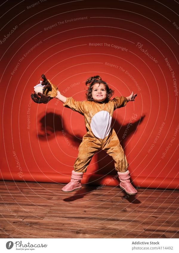 Cute little girl in deer costume jumping in studio kid cute happy joy cheerful adorable active child female infant innocent childhood disguise energy positive