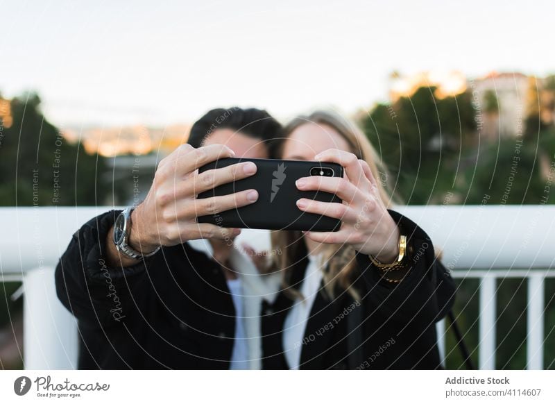 Happy multiethnic couple taking selfie in city smartphone happy together bridge young street urban lifestyle device gadget mobile relationship multiracial