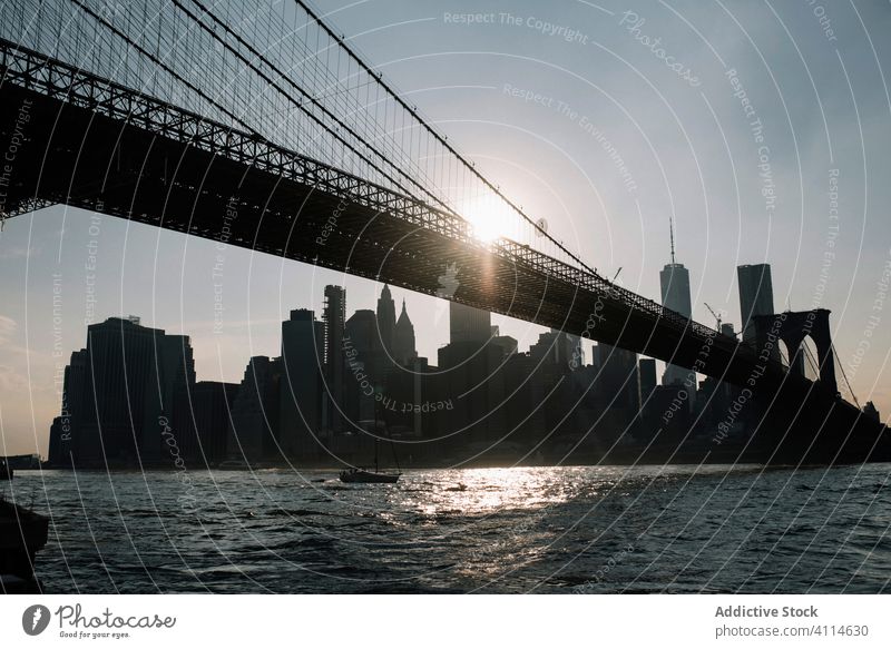 Modern cityscape with bridge over river in evening skyscraper new york sunset building urban architecture brooklyn water modern metropolis downtown usa