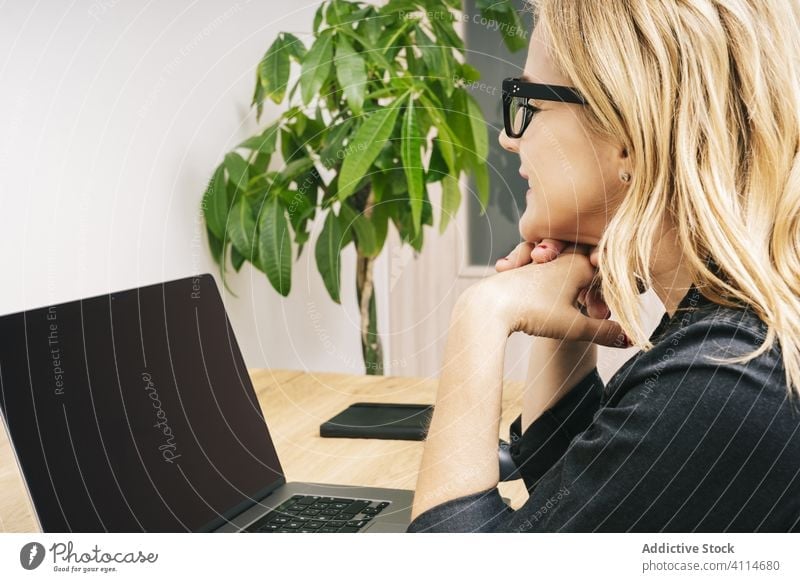 Woman working from her studio office at home woman desk computer business adult eyeglasses laptop caucasian browsing typing businesswoman internet home-office