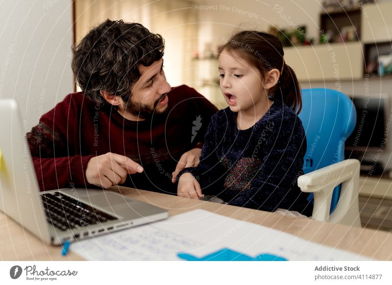 Father helping daughter with remote studies father study laptop home education together relationship man girl kid child parent sit childhood lifestyle love
