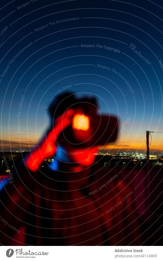Young man exploring virtual reality night vr dark street headset goggles futuristic illuminate neon red light male modern device gadget 3d sky technology
