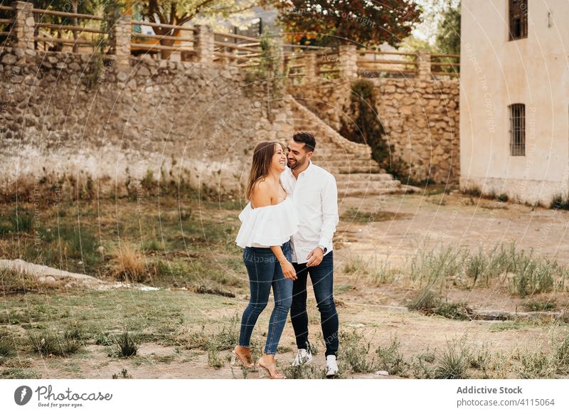 Happy couple in old yard love laugh together building stone relationship happy woman exterior young date aged boyfriend girlfriend affection joy casual relax