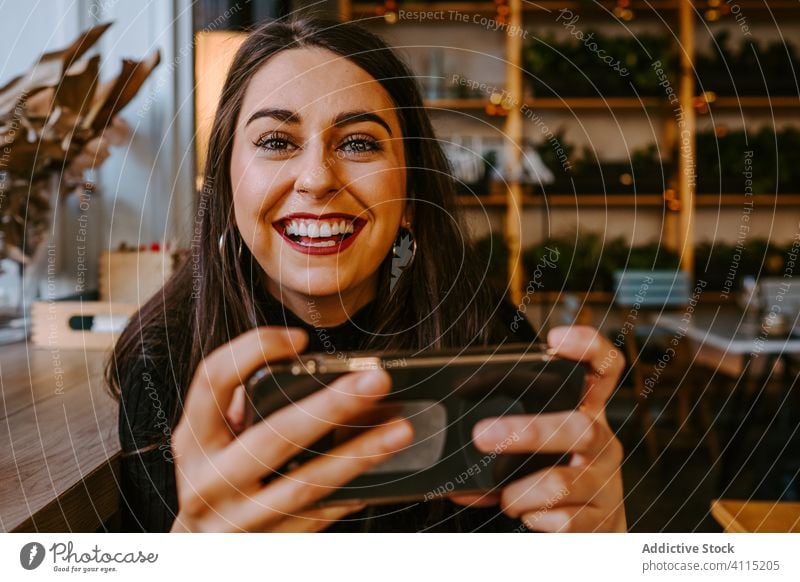 Young lady using smartphone in cafe woman style rest sit window modern young female outfit browsing cozy restaurant break mobile trendy lifestyle internet joy