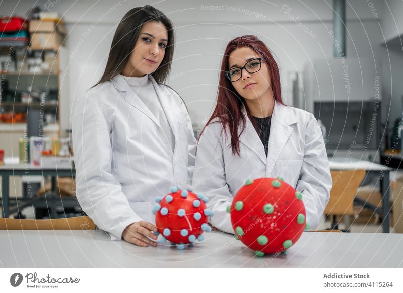 Students examining molecule models in lab student scientist laboratory work professional study women examine expertise research occupation education coat