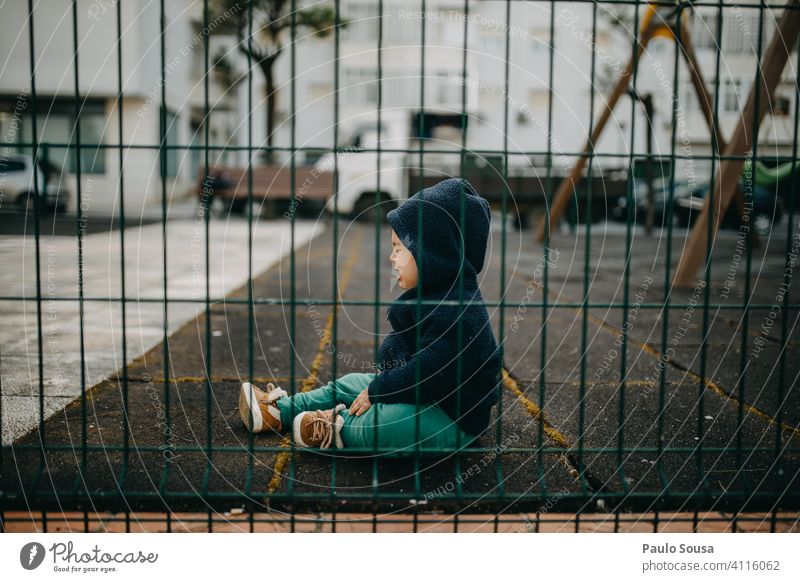 Child crying in the playground childhood 1 - 3 years Cry Caucasian side view through Fence Emotions Playground Exterior shot Lifestyle Infancy Toddler