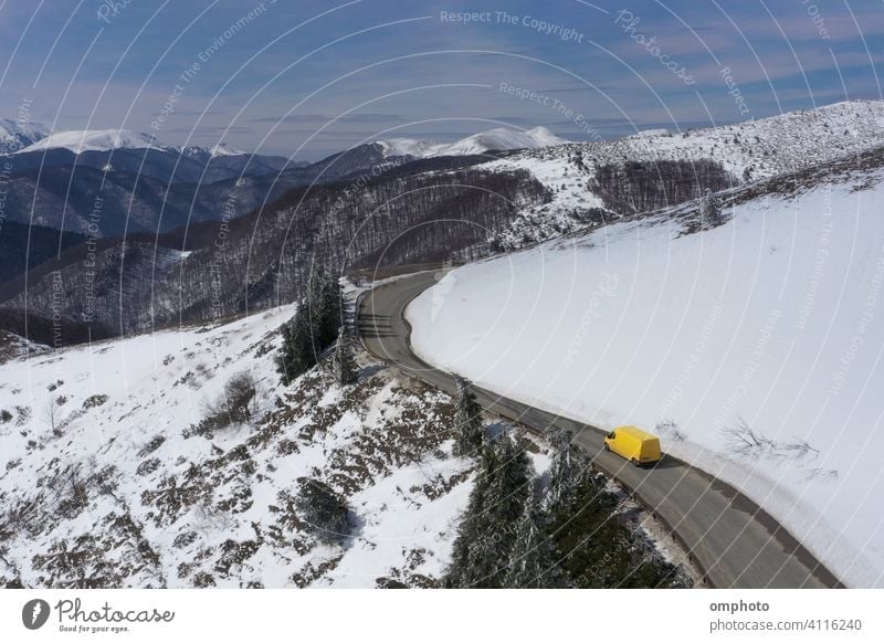 Microbus Truck Moving on a Mountain Winter Road truck car snow winter mountain vehicle yellow snowy road white drive transportation landscape cold weather