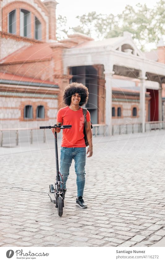 Young Black Boy Looking at Camera front view looking at camera afro young man boy black african american smiling urban electric scooter outside happy riding