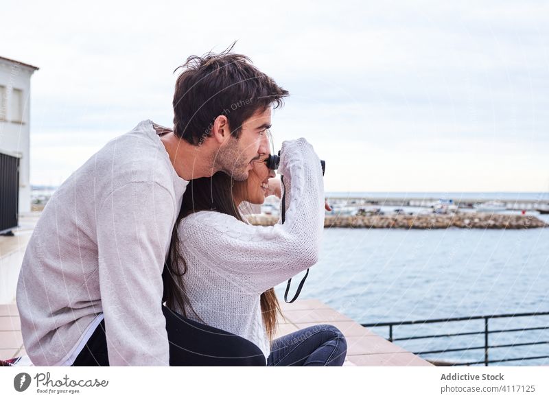 Happy young couple with binoculars resting at seaside happy terrace cheerful romantic enjoy holiday casual together vacation love travel relationship relax