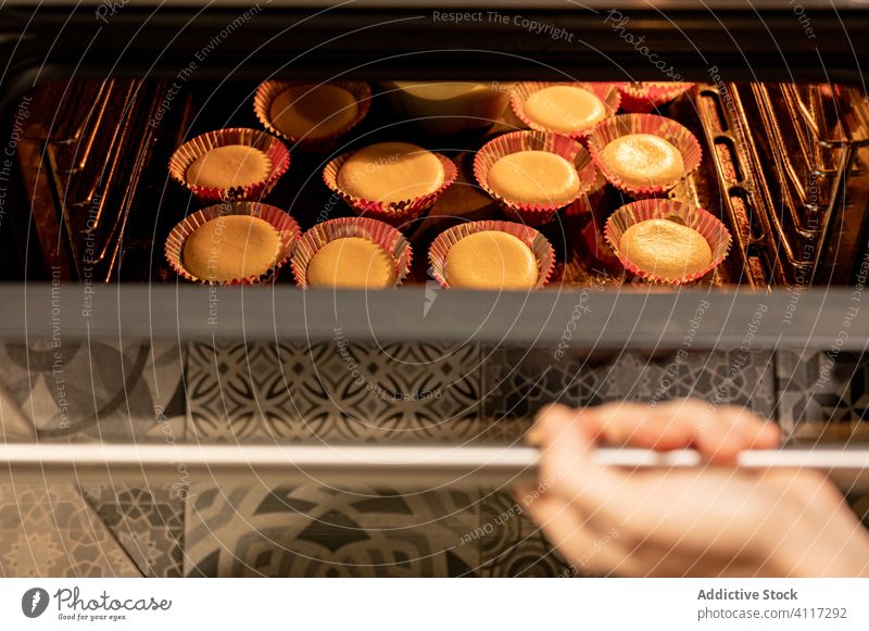 Crop person checking cupcakes in oven bake home kitchen pastry open hot food tray muffin dessert stove dish meal prepare appliance sweet snack fresh lifestyle