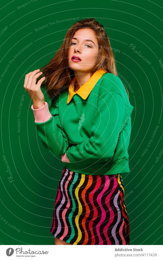Thoughtful woman in colorful outfit looking at camera thoughtful pensive young green style serious female model retro confident expressive cloth bright garment