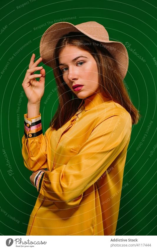 Stylish female model looking at camera woman trendy style colorful outfit young fashion confident hat summer sensual urban millennial chill serious