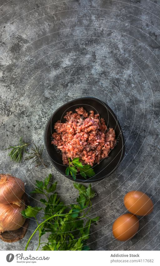 Herbs, eggs and onions near minced meat herb table kitchen rustic salt fresh food cuisine ingredient gourmet nutrition lunch dinner homemade seasoning protein
