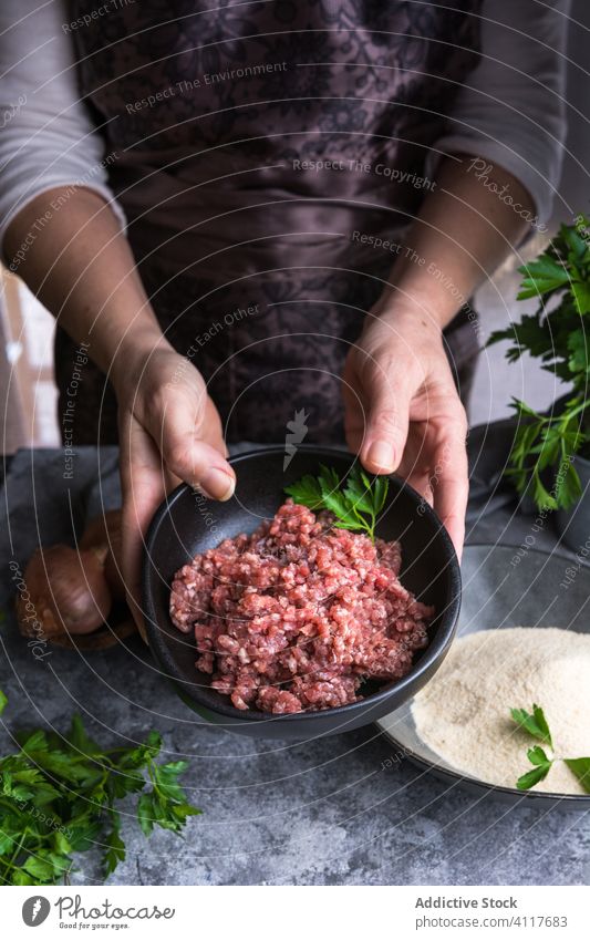 Crop woman showing minced meat parsley cook table food meal fresh prepare cuisine rustic kitchen ingredient gourmet dish nutrition recipe lunch culinary