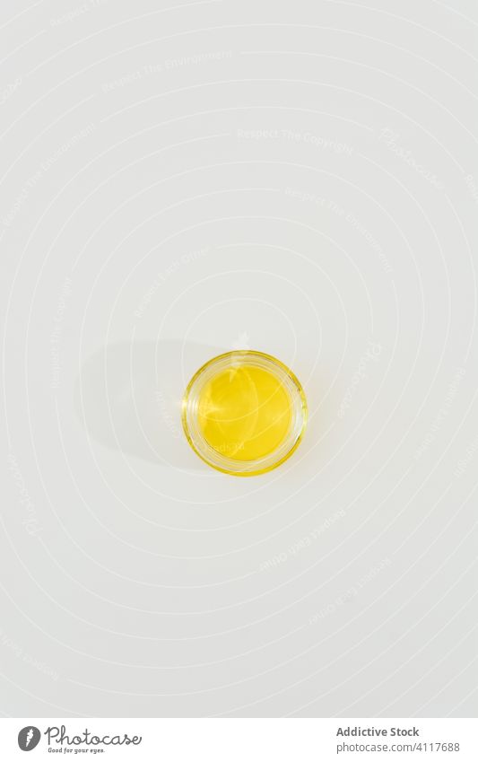 Glass with oil on white background olive glass natural healthy ingredient organic food nutrition diet cup fresh vegetarian meal cuisine yellow cook minimal