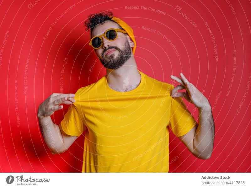 Stylish man grimacing and gesticulating gesture style fun modern colorful bright male outfit trendy vivid joy excited hipster cool sunglasses hat t shirt guy