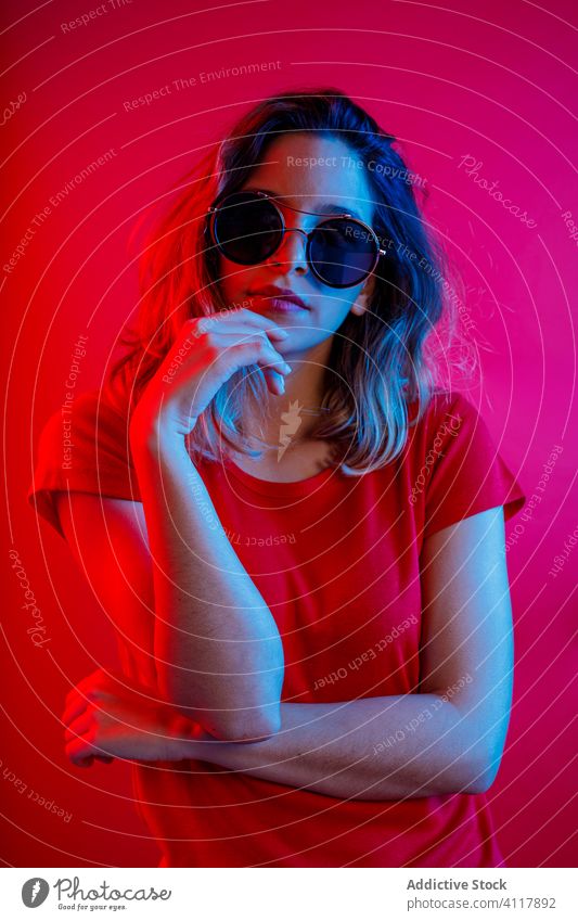 Woman looking at camera camera woman thoughtful outfit modern colorful neon illuminate bright model female young vibrant trendy vivid joy gesture contemporary