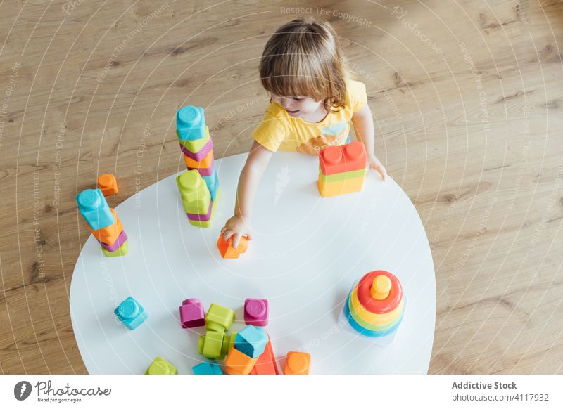 Little kid playing with colorful toys pyramid build block stack preschool infant girl develop little education kindergarten child baby childhood adorable cute