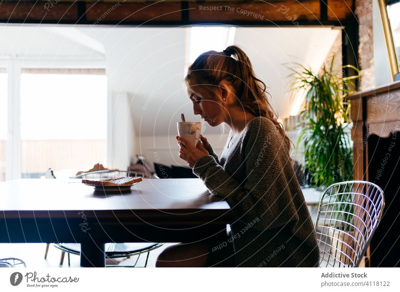 Sad woman having breakfast alone at home pensive sad coffee morning depression thoughtful young female drink beverage cup lonely unhappy upset distance