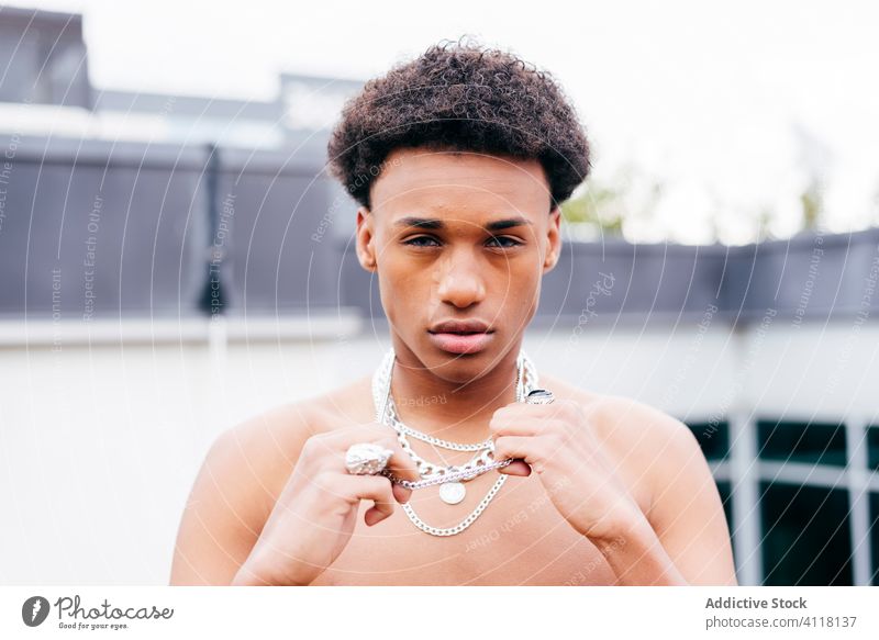 Shirtless ethnic man with chain necklaces trendy cool street style naked torso young confident modern black african american male urban fashion contemporary