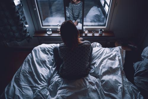 Lonely woman looking at mirror dark solitude bed depression window home female reflection apartment lonely silent melancholy shadow obscure flat gloomy cozy